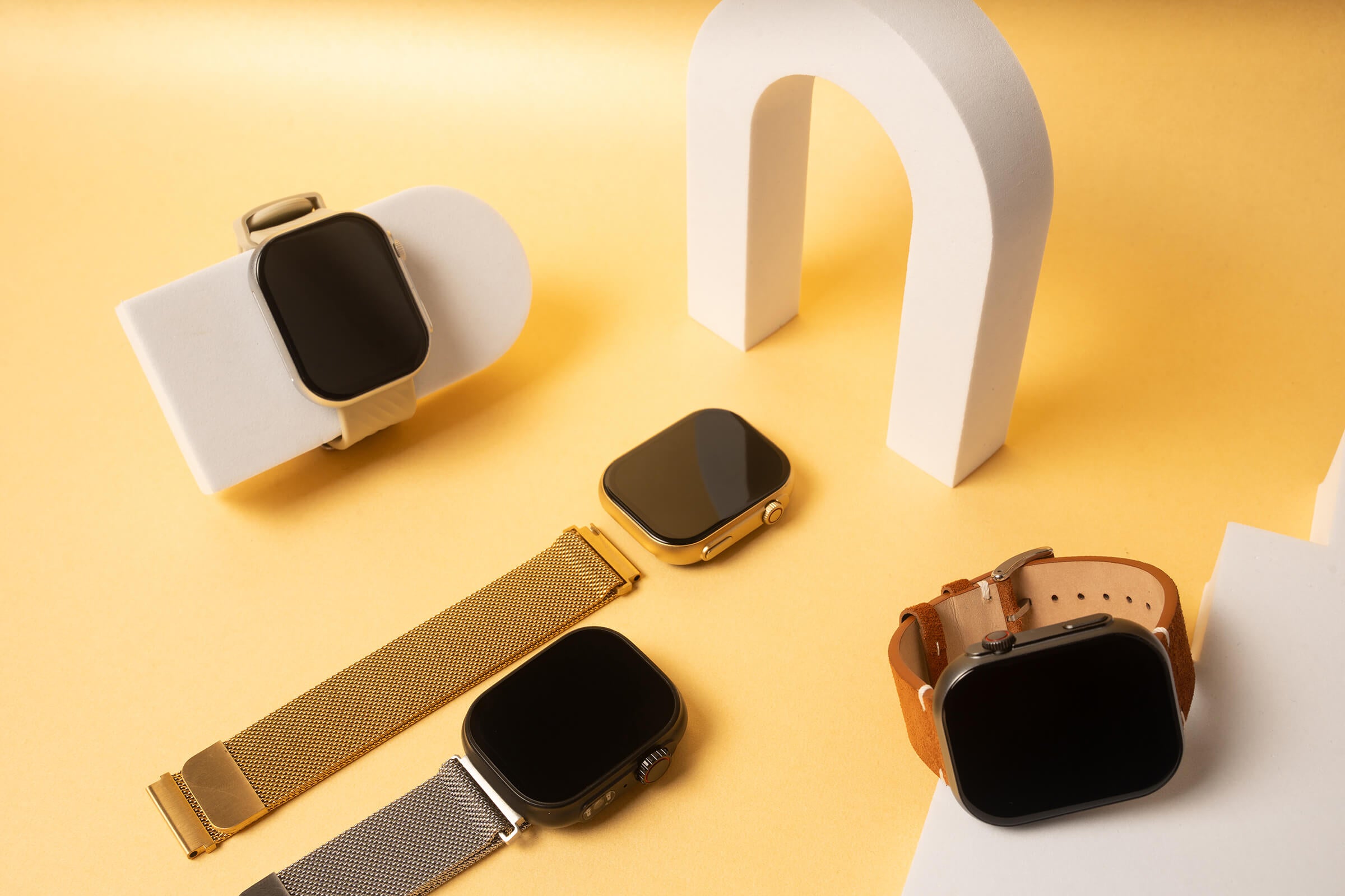 Mixed Laggios smartwatches and bands in a custom yellow background with props.