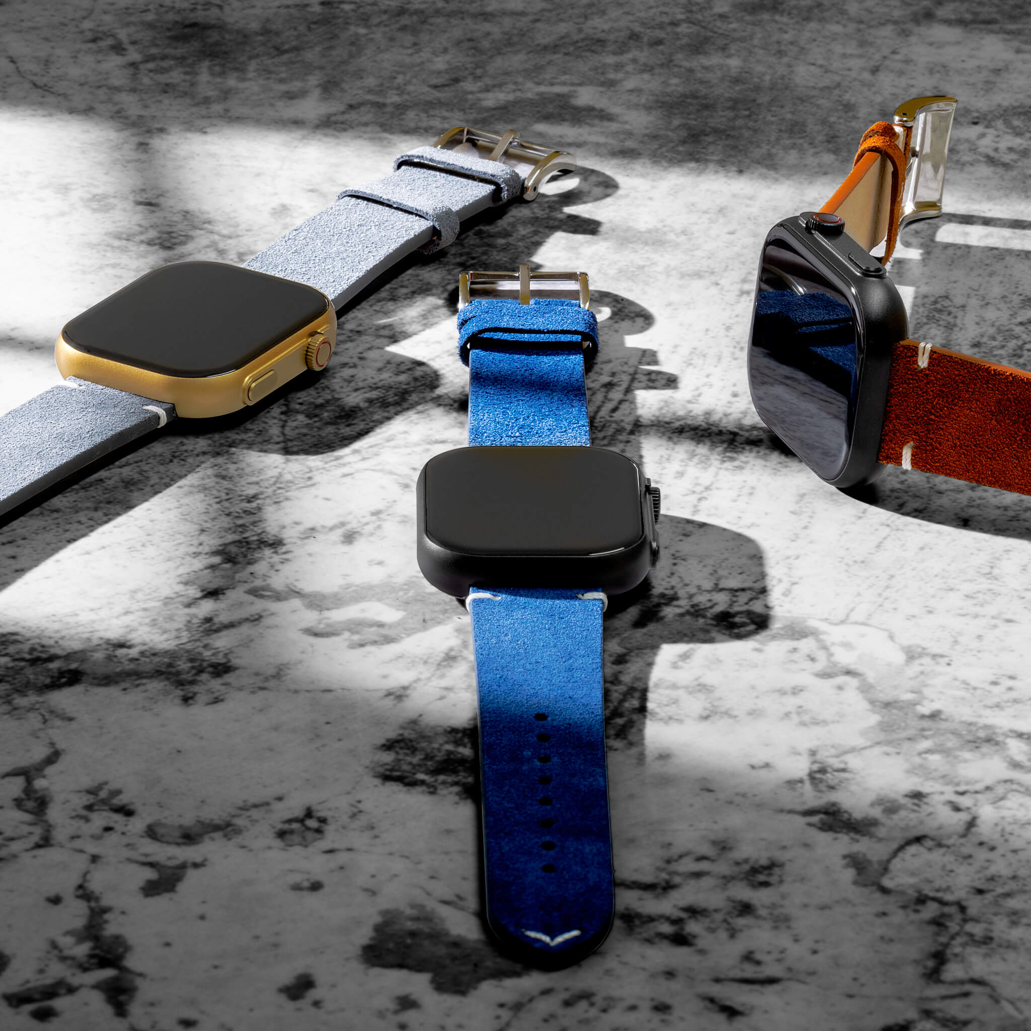 Three prime smartwatches in suede straps in a custom marbled background.